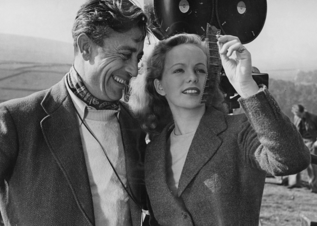 Freddie Young stands with actress Peggy Cummins on the set of ‘Escape’.