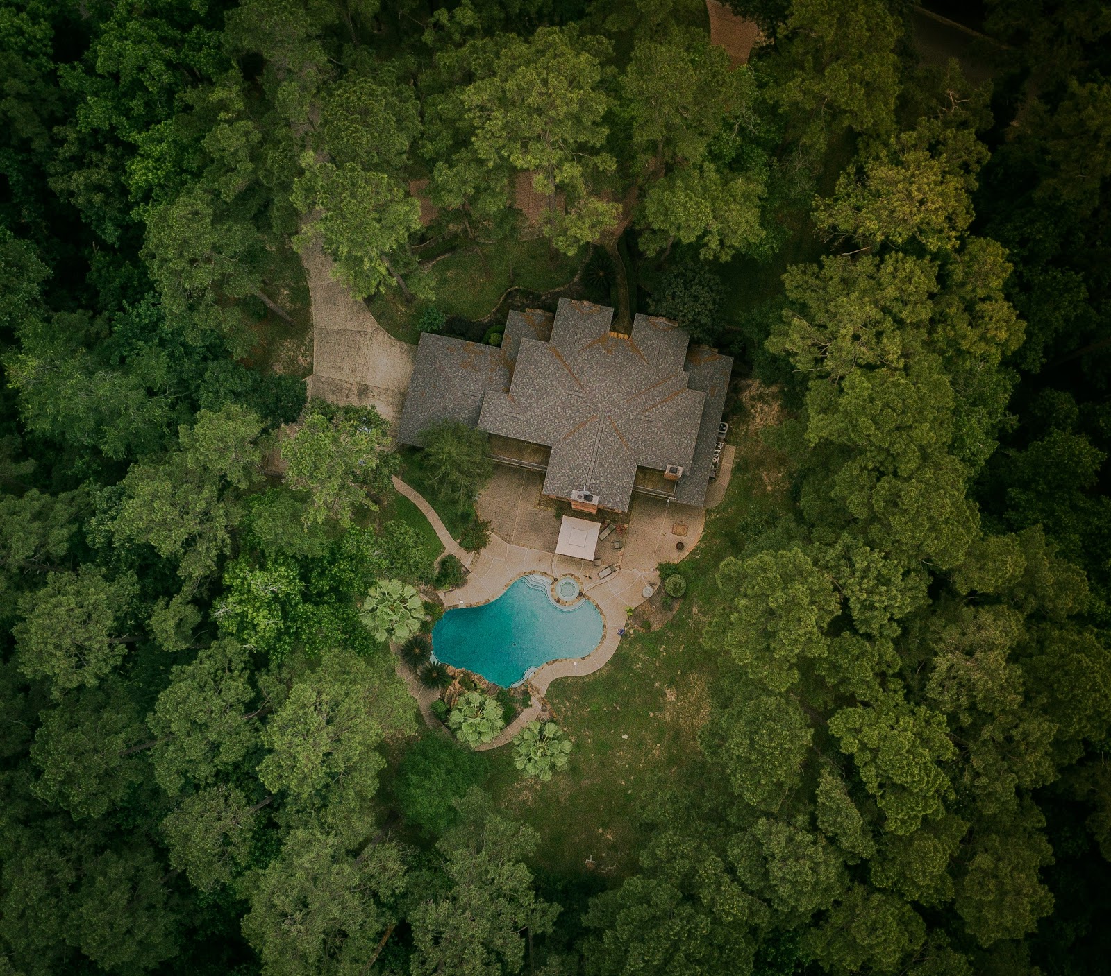 Aerial view of a house in a heavily wooded area