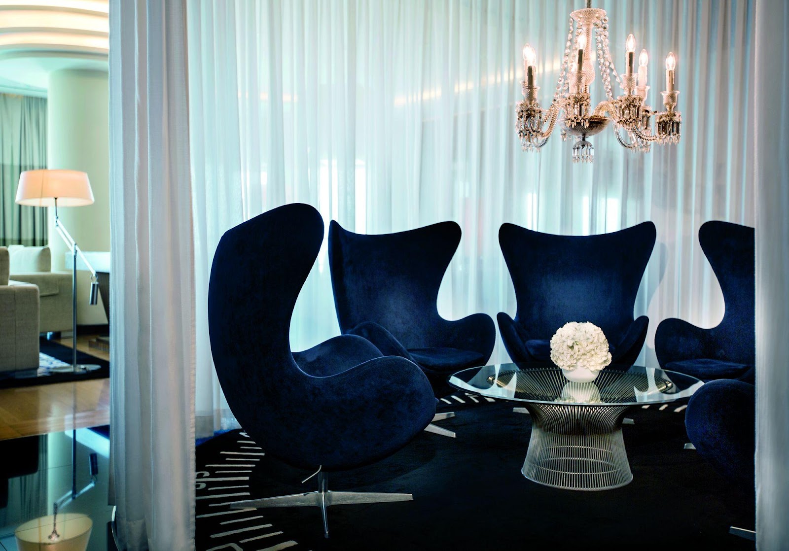 Five cocoon-like chairs in navy velvet form a circle in a semi-private space within the Club Lounge