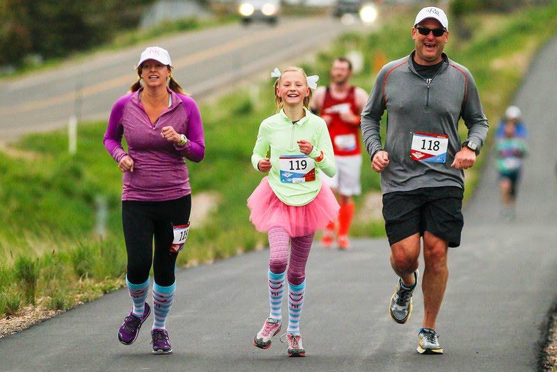 Three runners on a paved trail in the Runners with Ed race in Park City, Utah.