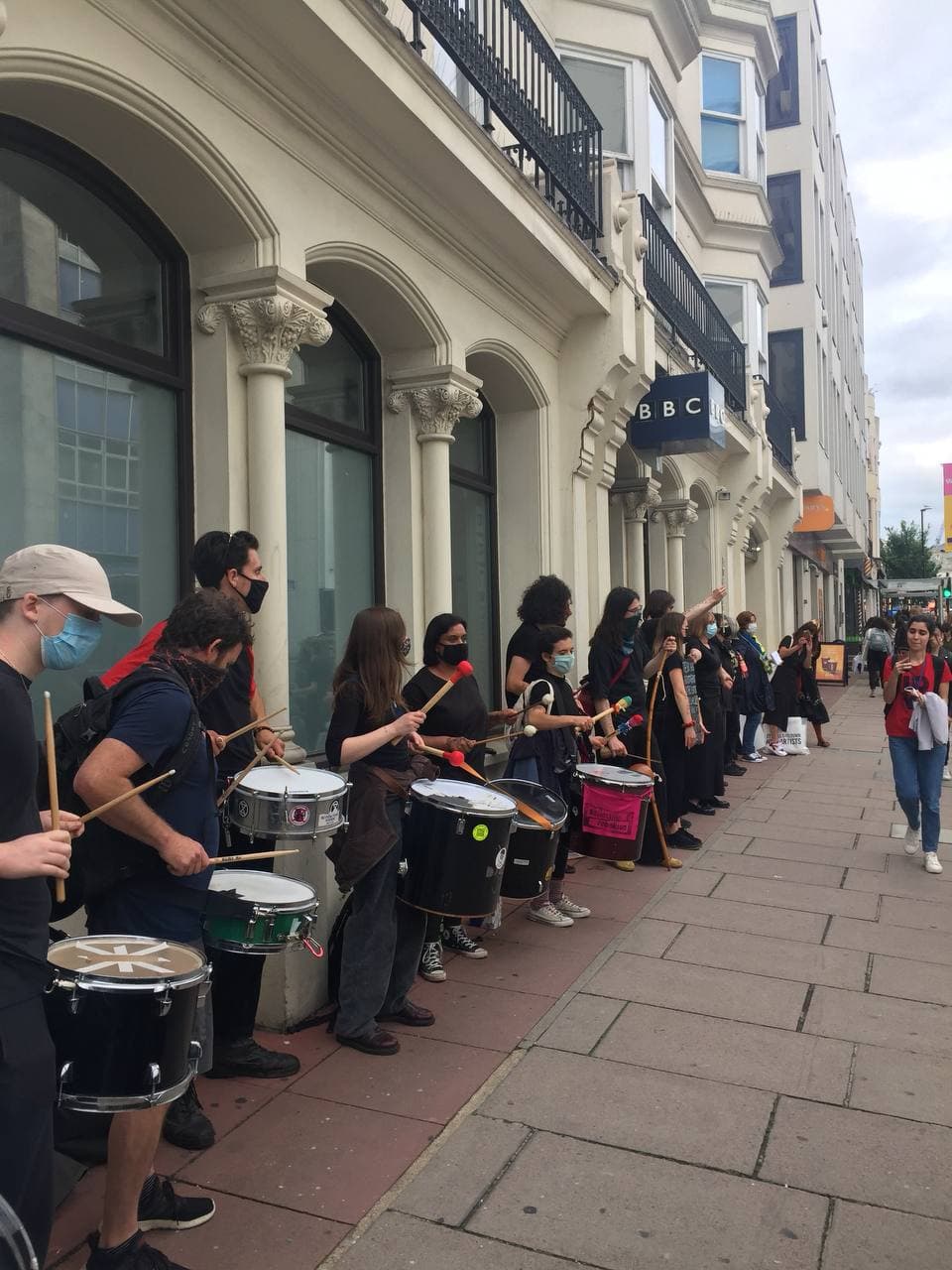 Photo of protesters drumming in the streets of Brighton