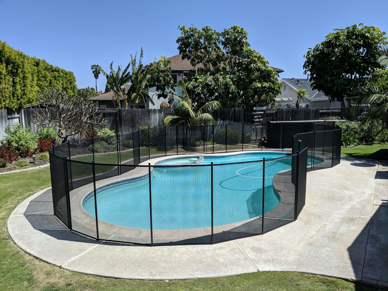 black mesh removable pool fencing installed around a swimming pool