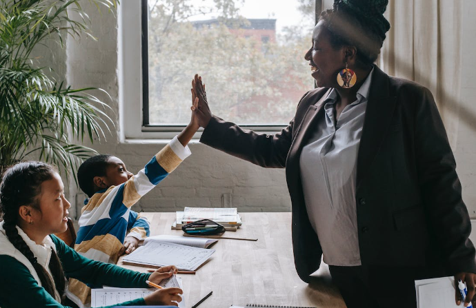 A student giving a high five to his teacher
