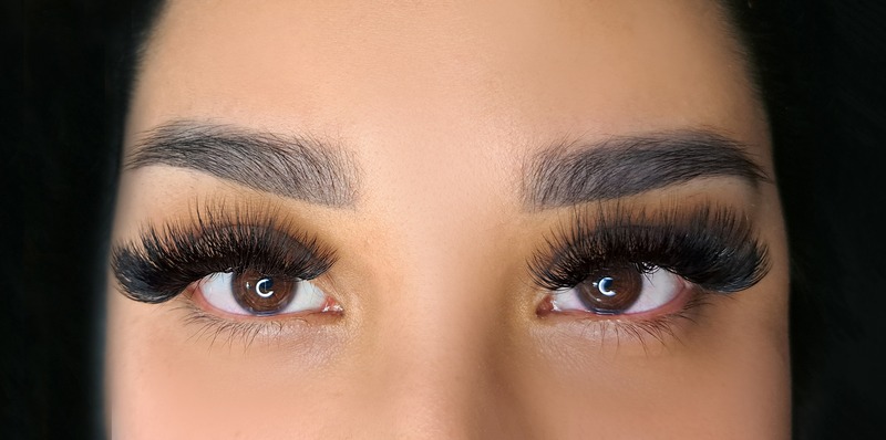 volume lash extensions - closeup of woman’s eyes with dramatic lash style
