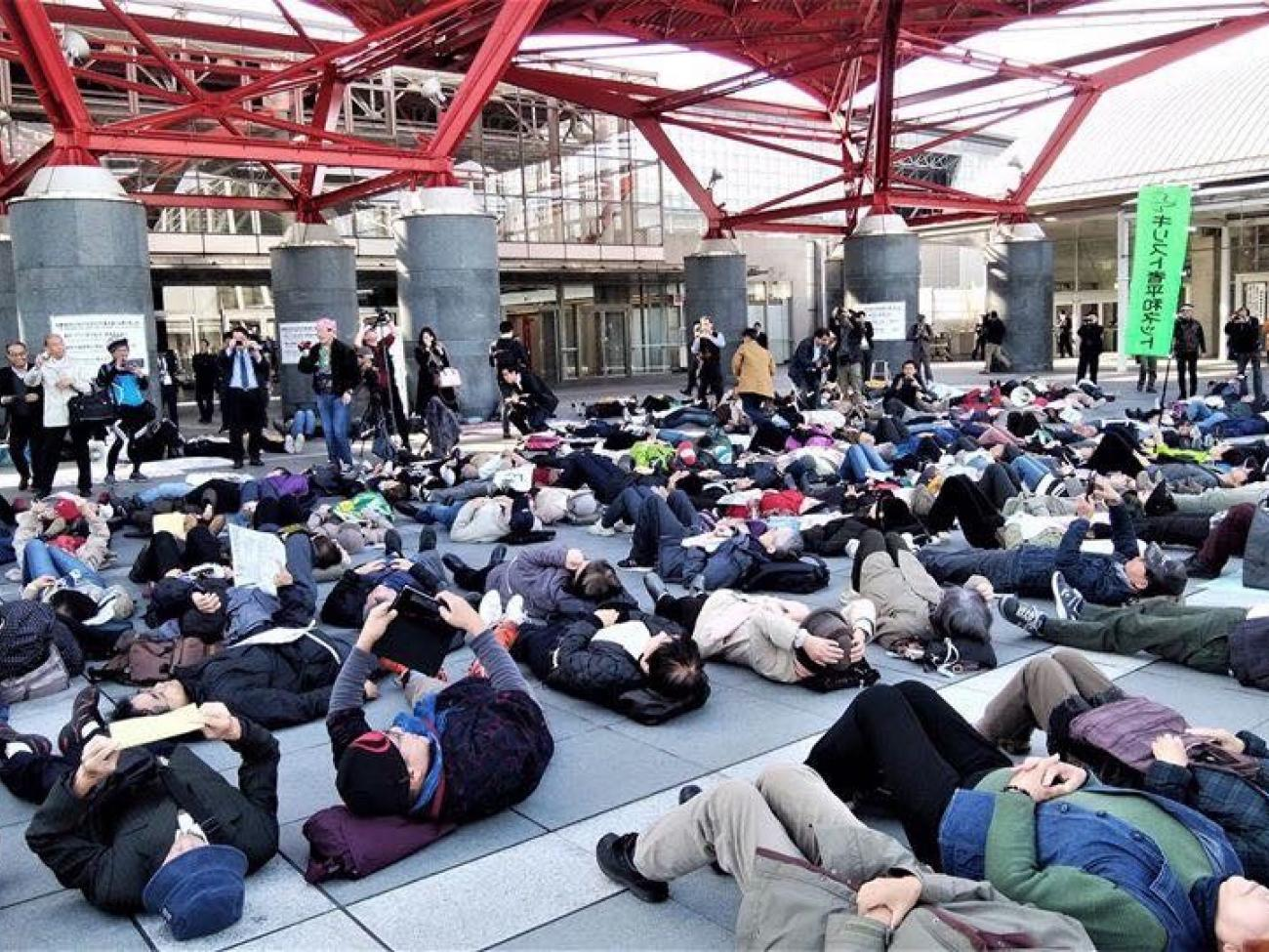 Activists stage a die-in outside the Japan DSEI arms fair, Chiba