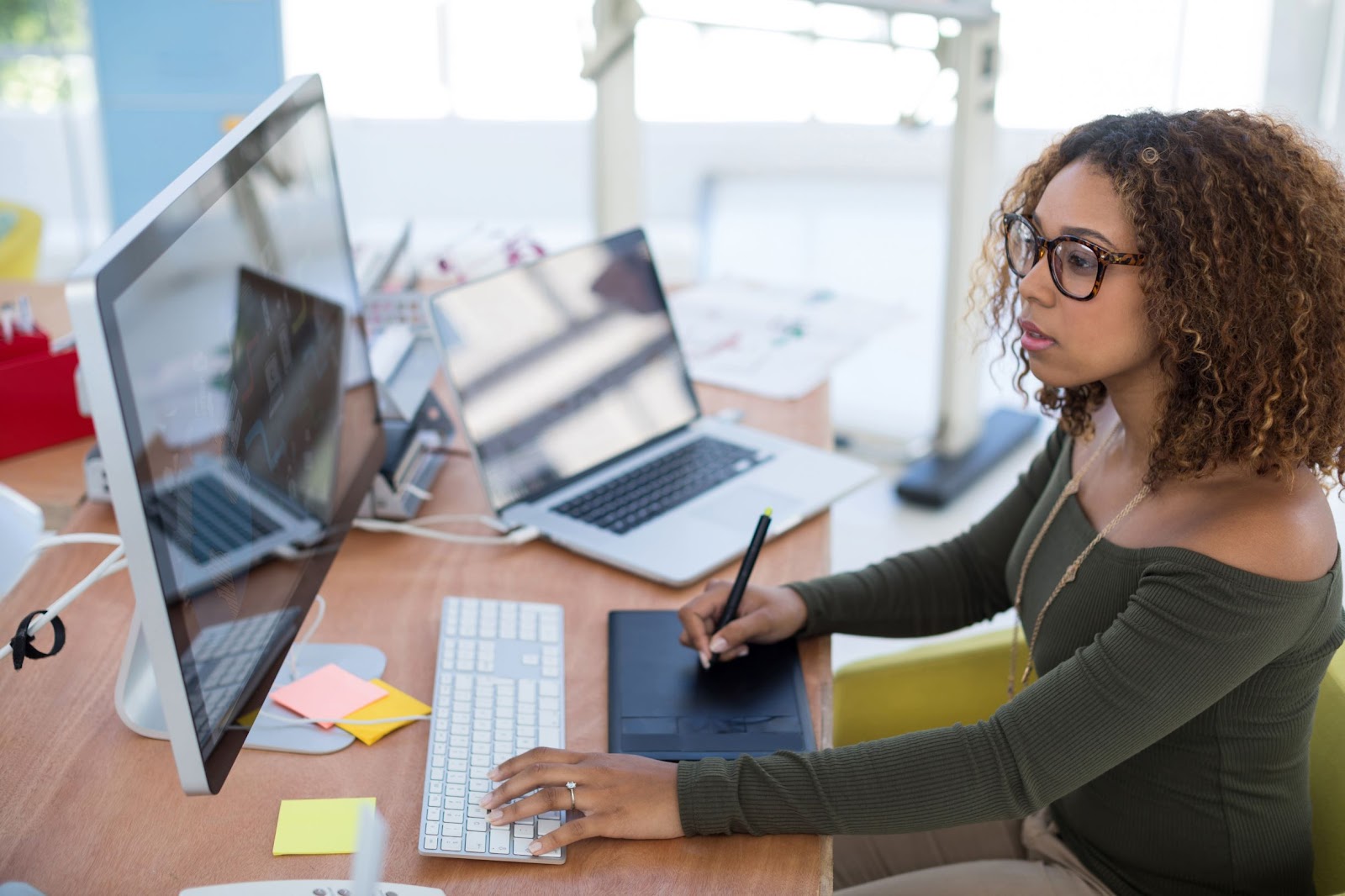 Imagem de uma mulher negra, em frente a uma tela de computador, que visa ilustrar a qualidade do trabalho em conjunto com os serviços de armazenamento em nuvem