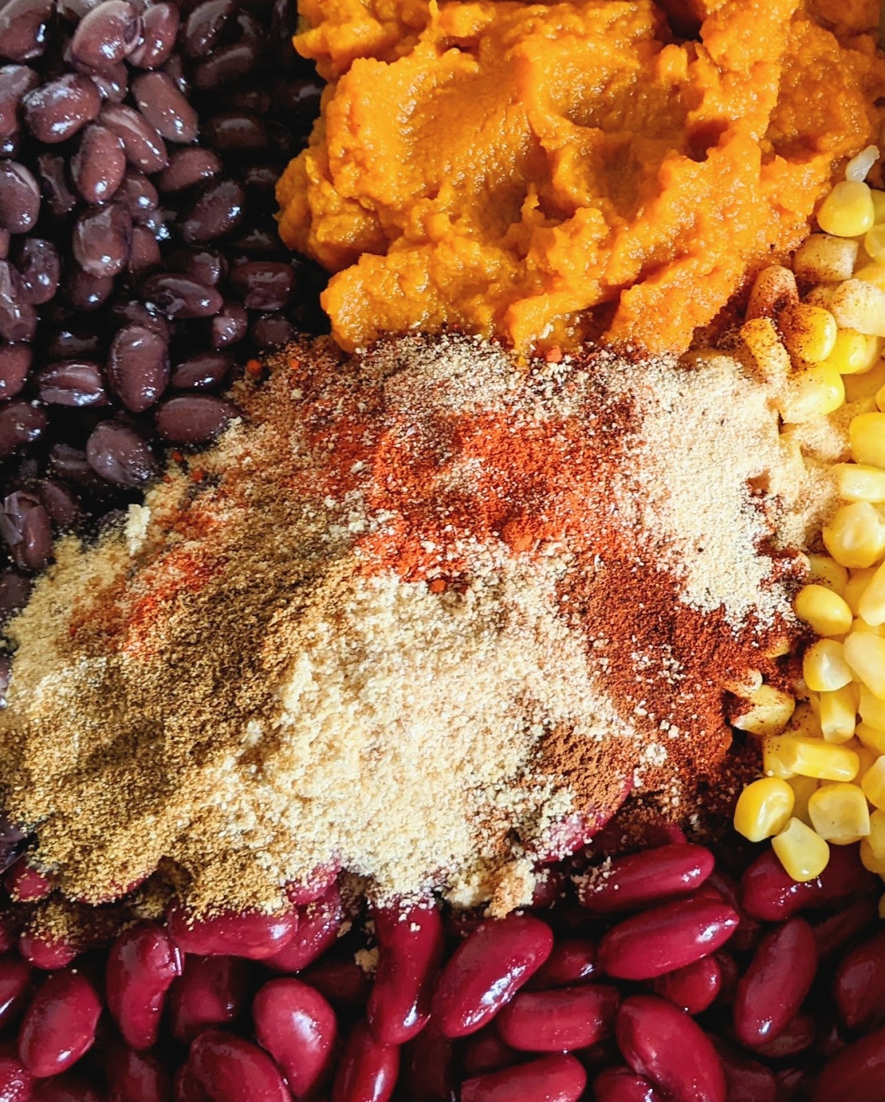 close up view of ingredients needed to make this chili including beans, spices and corn