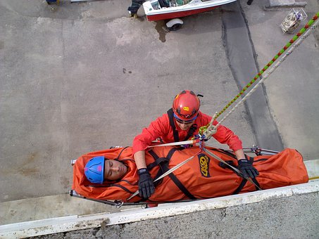 an injured worker is prepared by another worker to be airlifted to safety