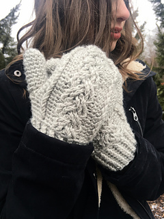 woman wearing cream colored cabled crochet mittens