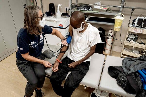 An aid group worker on Sunday checked the health of a migrant on the Ocean Viking off the coast of Italy.