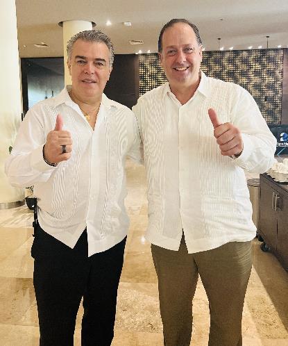 Two men in white shirts giving thumbs up

Description automatically generated