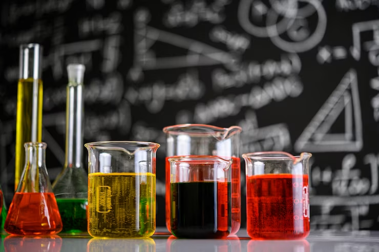 Laboratory glassware with colorful liquids, representing the practical application of concepts in MCAT General Chemistry.