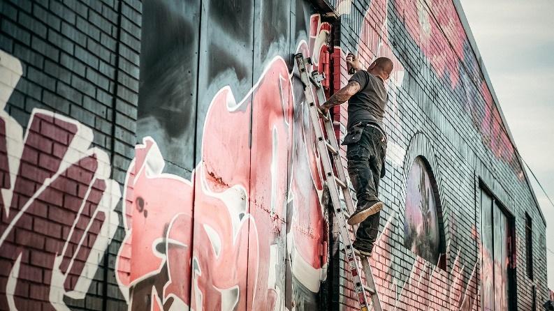 A contractor painting over graffiti 