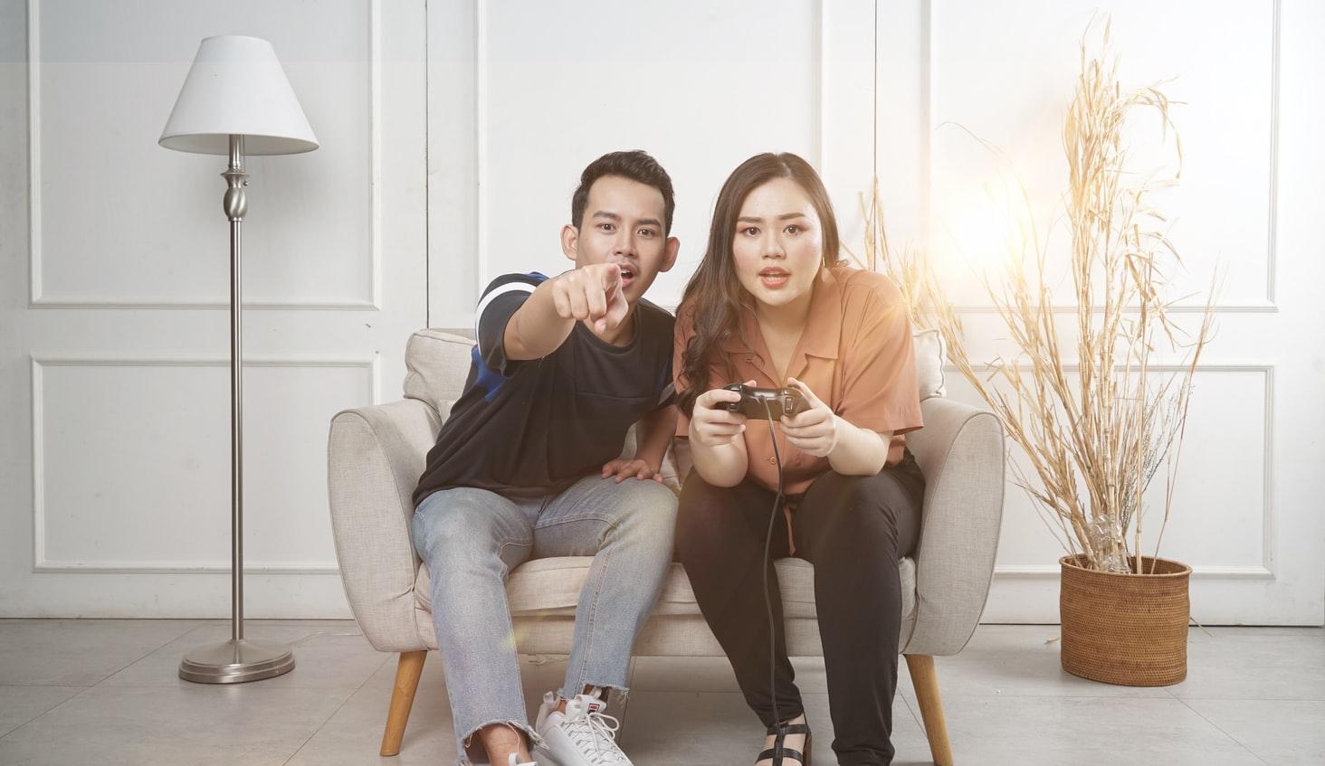 A person and person sitting on a couch playing video games

Description automatically generated with medium confidence