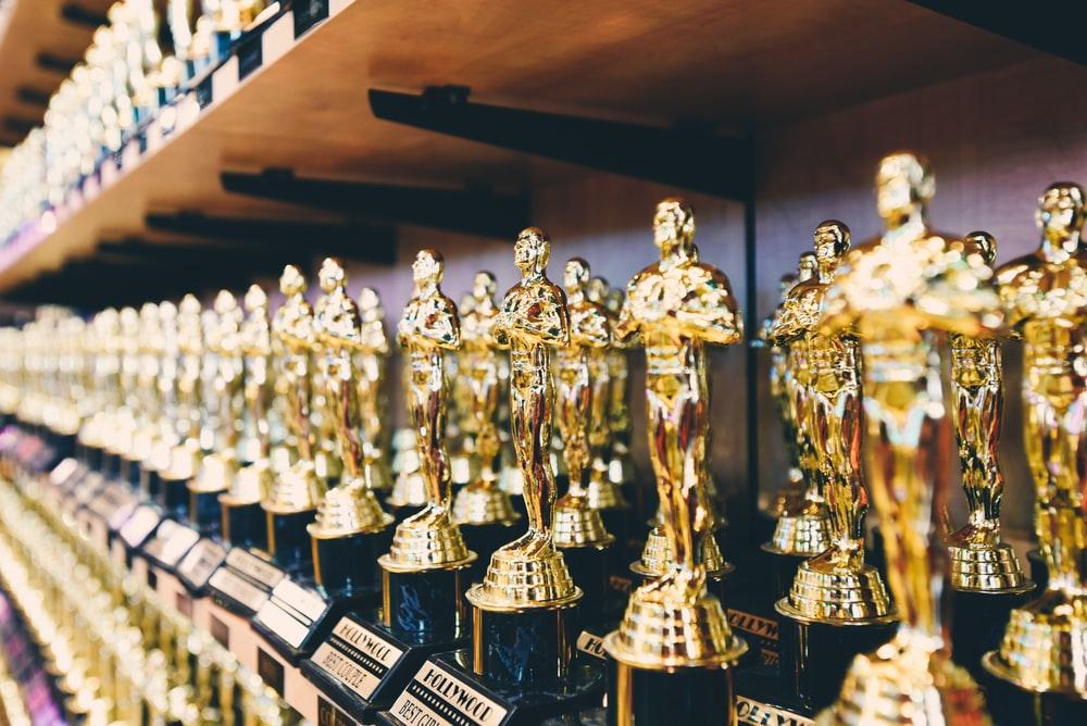 A set of gold trophies aligned on a shelf