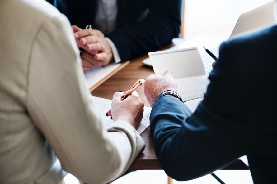people at a table looking over contracts