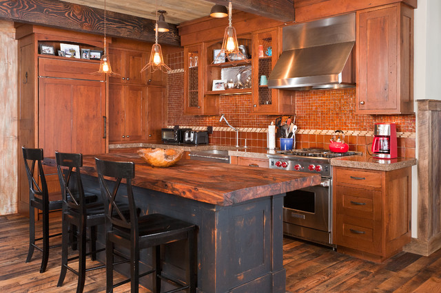 This cabin kitchen is completed by a thick reclaimed wood slab island. The various wood stains in the design enhance the rustic feel of the space.