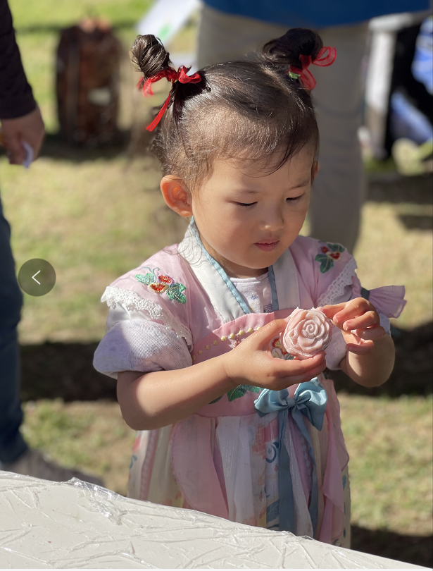 A child holding a flower

Description automatically generated