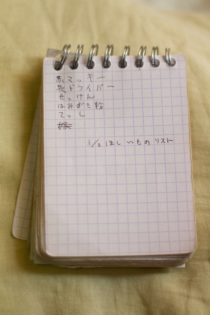 日本語で買うものがメモしてあるワイヤー綴じのメモ帳の画像です。