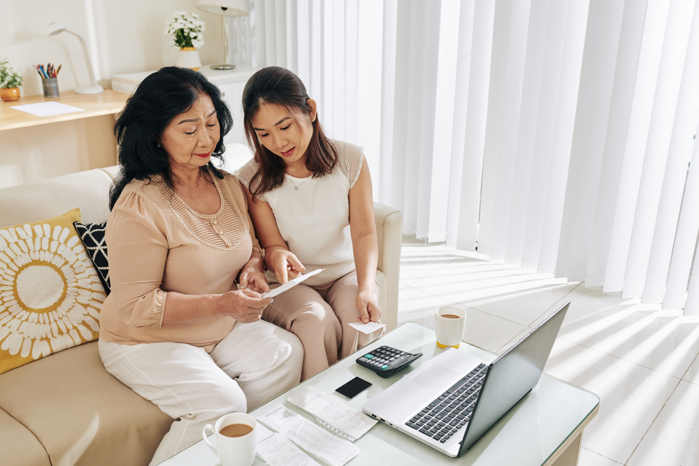 Young Asian woman helping her senior mother use computer for internet.