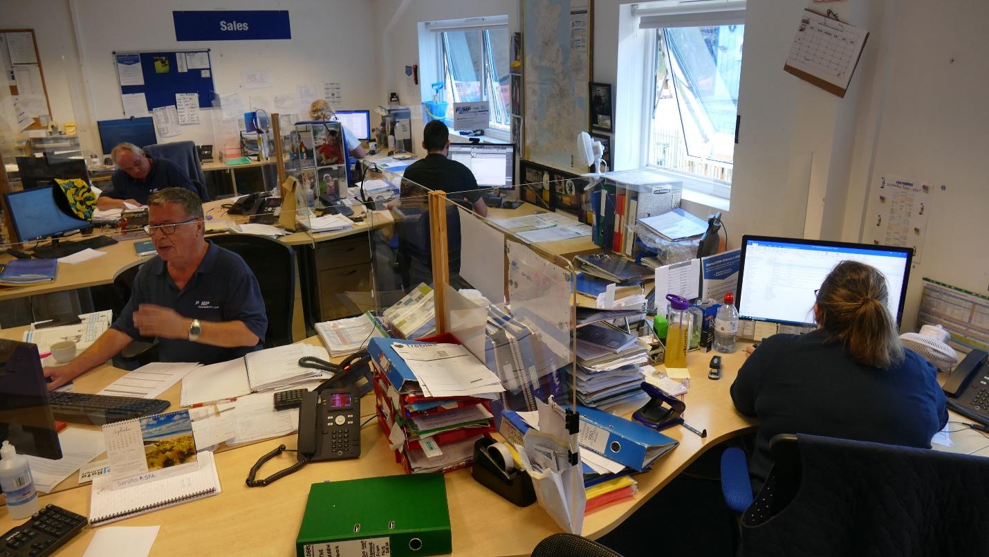 A group of people sitting at a table with computers

Description automatically generated with low confidence