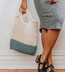 woman carrying a teal and white crochet tote