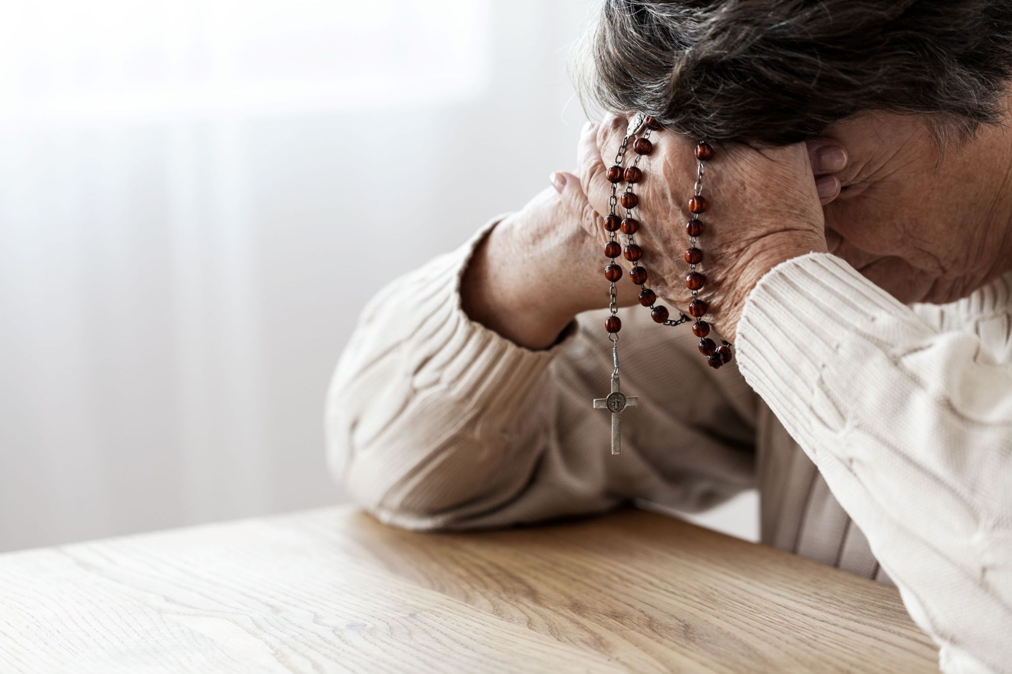 older-woman-praying-with-rosary