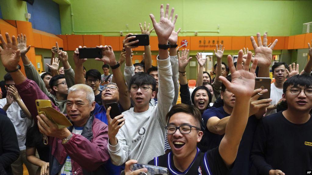 香港选民在他们支持的一名民主派候选人在区议会选举中获胜后举手欢呼。(2019年11月25日)