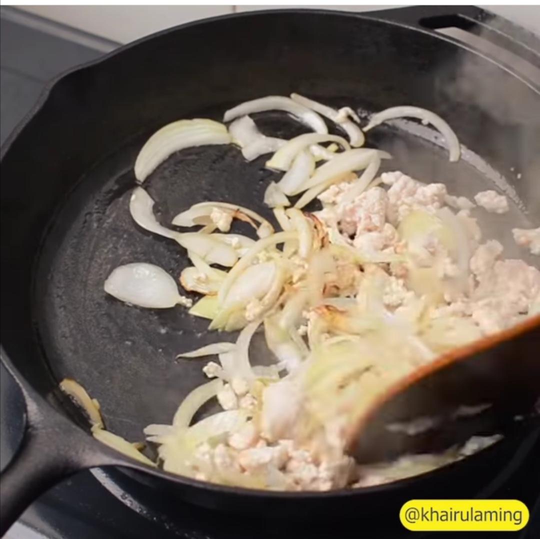 A bowl of food cooking on a black pan on a stove

Description automatically generated