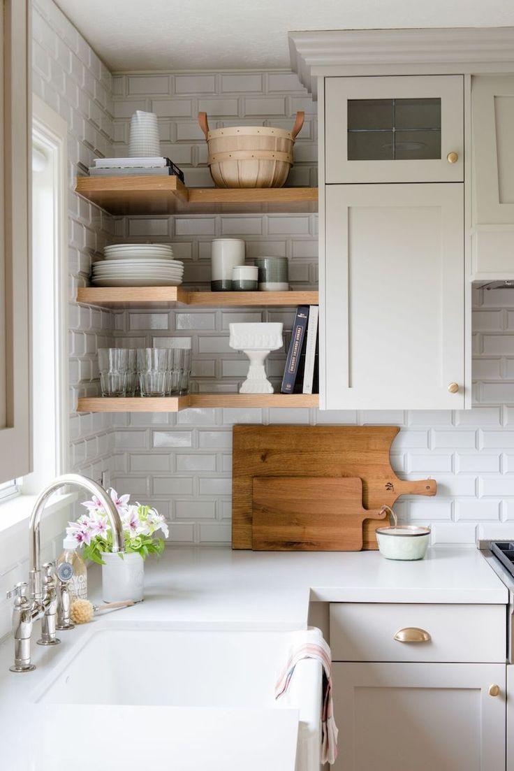 shaker cabinet kitchen paired with open shelving in the corner. three wood shelves are used to store extra dishware and decor