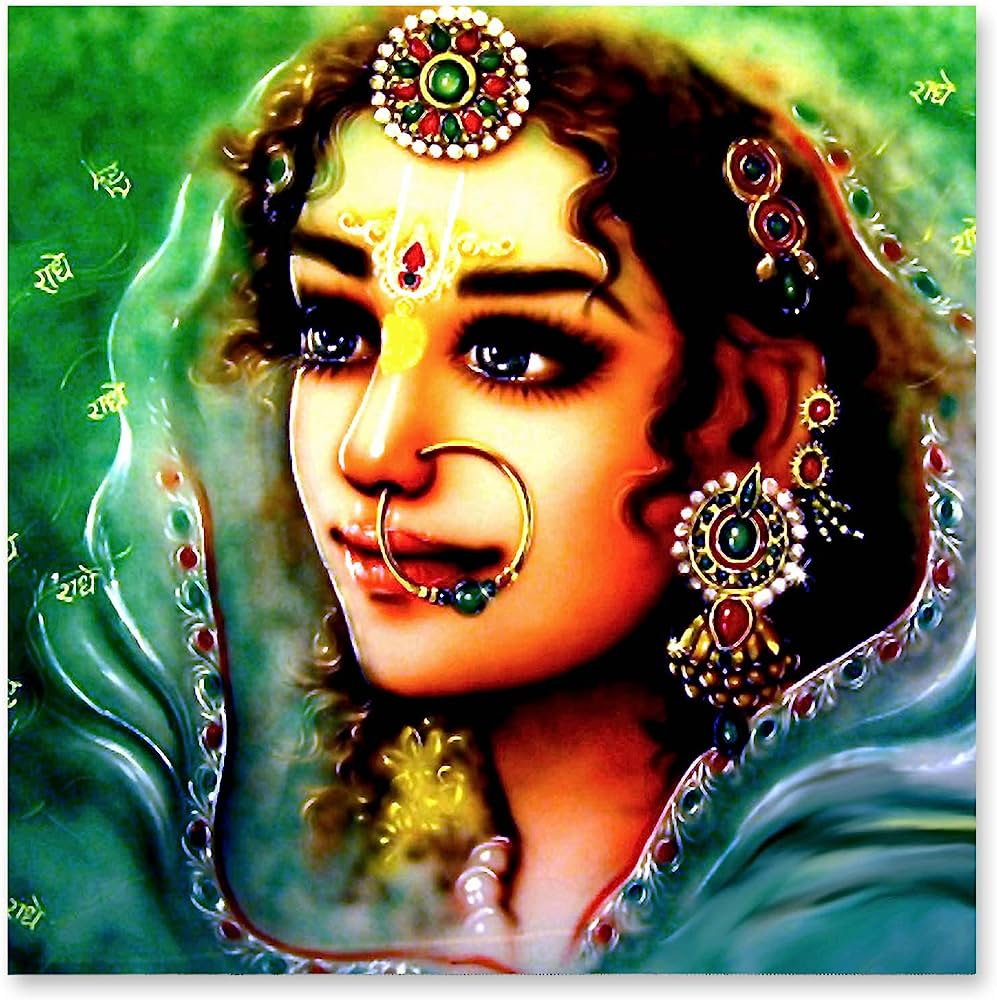 Featured here is an illustration of the beautiful Radha, whose eyes are large and sparkling. She is wearing intricate jewelry and a blue dupatta that covers her head, with some of her hair peeking out. 