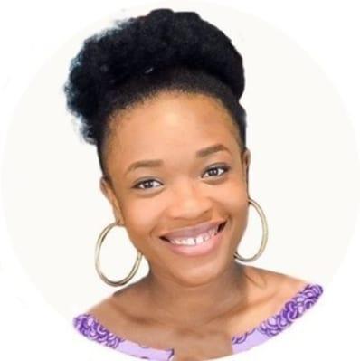 Adaobi Okonkwo, Nigerian influencer and creative director of Dobby's Signature, smiling in hoop earrings and a purple shirt - Top 25 Social Media Influencers Making Impacts in Nigeria Today.