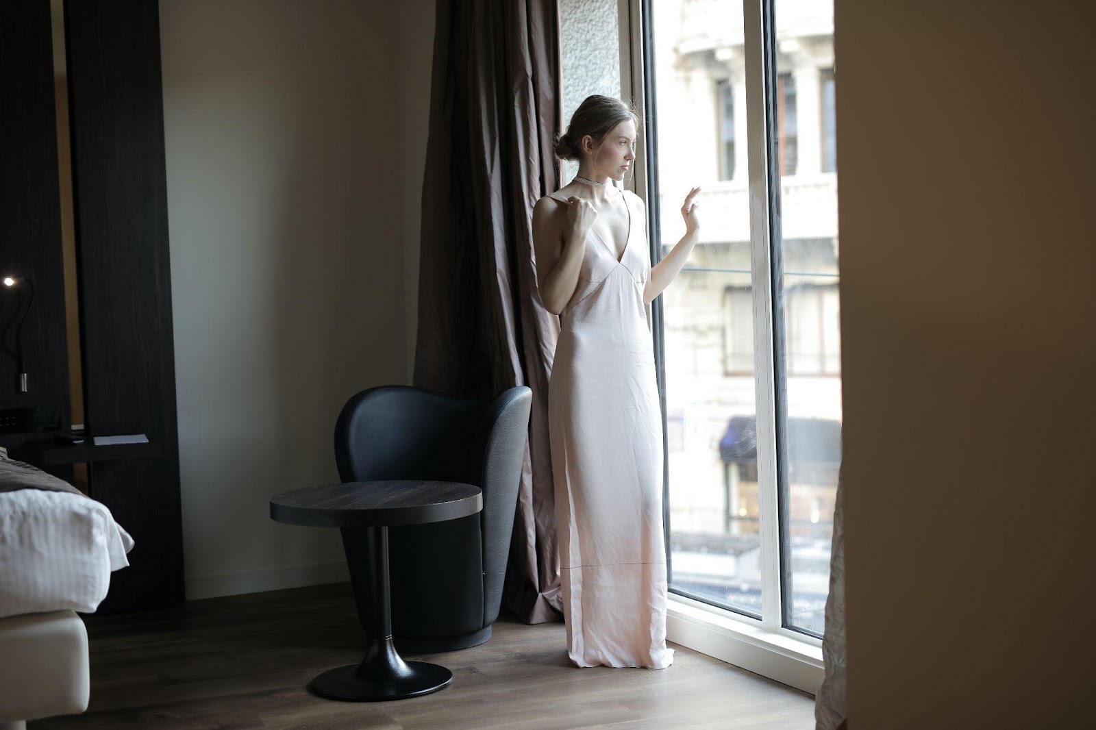 Woman looking out the window in a house dress