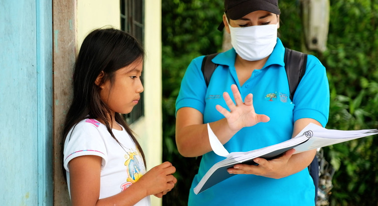 Una niña de 11 años en Ecuador recibe una guía para estudiar durante el cierre de escuelas por la pandemia de COVID-19