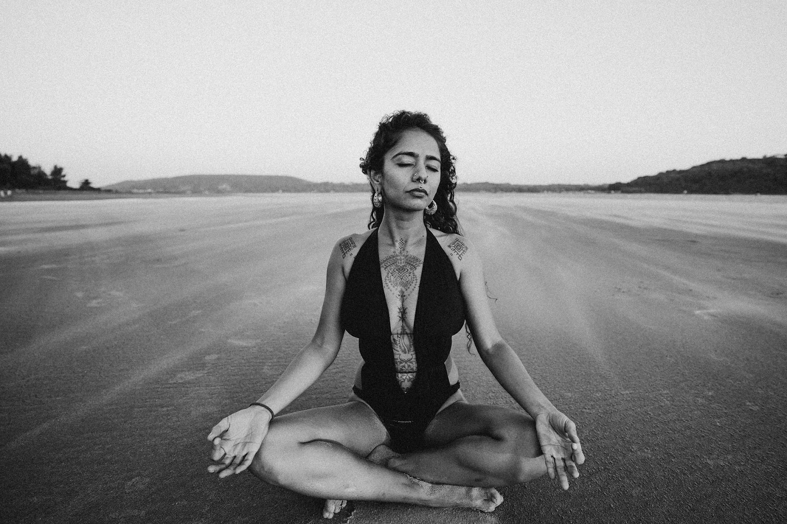 woman sitting on a beach meditating