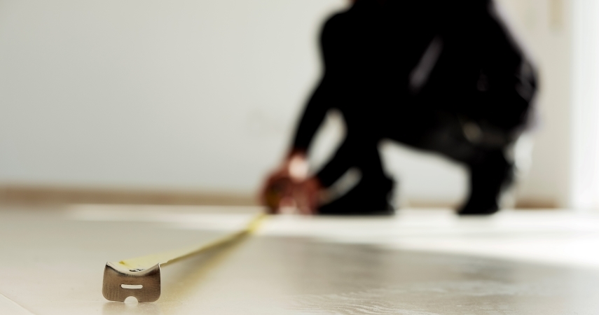 person measuring the floor of their high-rise apartment