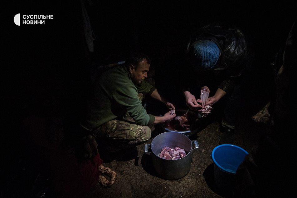 Після рубки чоловіки вправно перемивають м'ясо, яке необідне для приготування їжі військовим у Бахмуті. Донеччина, грудень 2022 року.