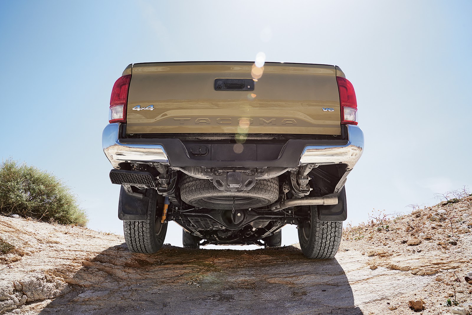 close-up of tailgate of brown Toyota Tacoma off-roading up a hill