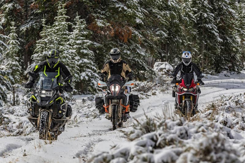 Get ready to blaze a new trail with three motorcyclists on a snowy wooden path