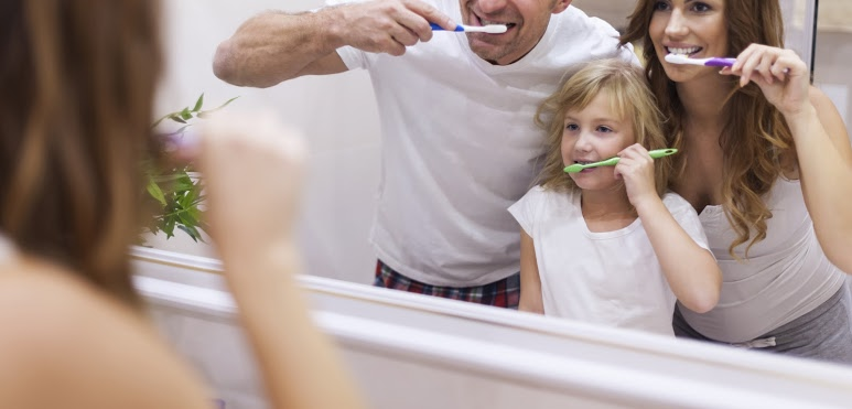 family brushing their teeth before bed and practicing good dental hygiene family brushing their teeth before bed and practicing good dental hygiene