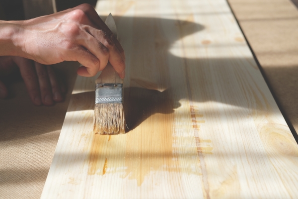 covering-impregnate-wooden-board-with-varnish-by-hand-with-paintbrush-