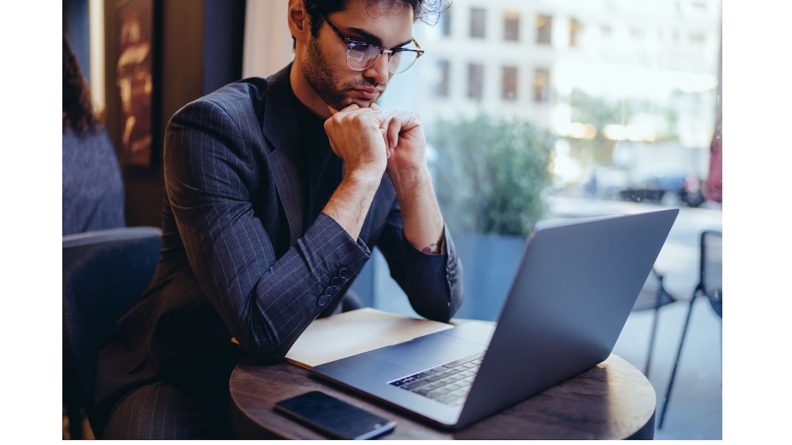 Concentrated male waiting for software update to complete on his laptop so he can continue with work