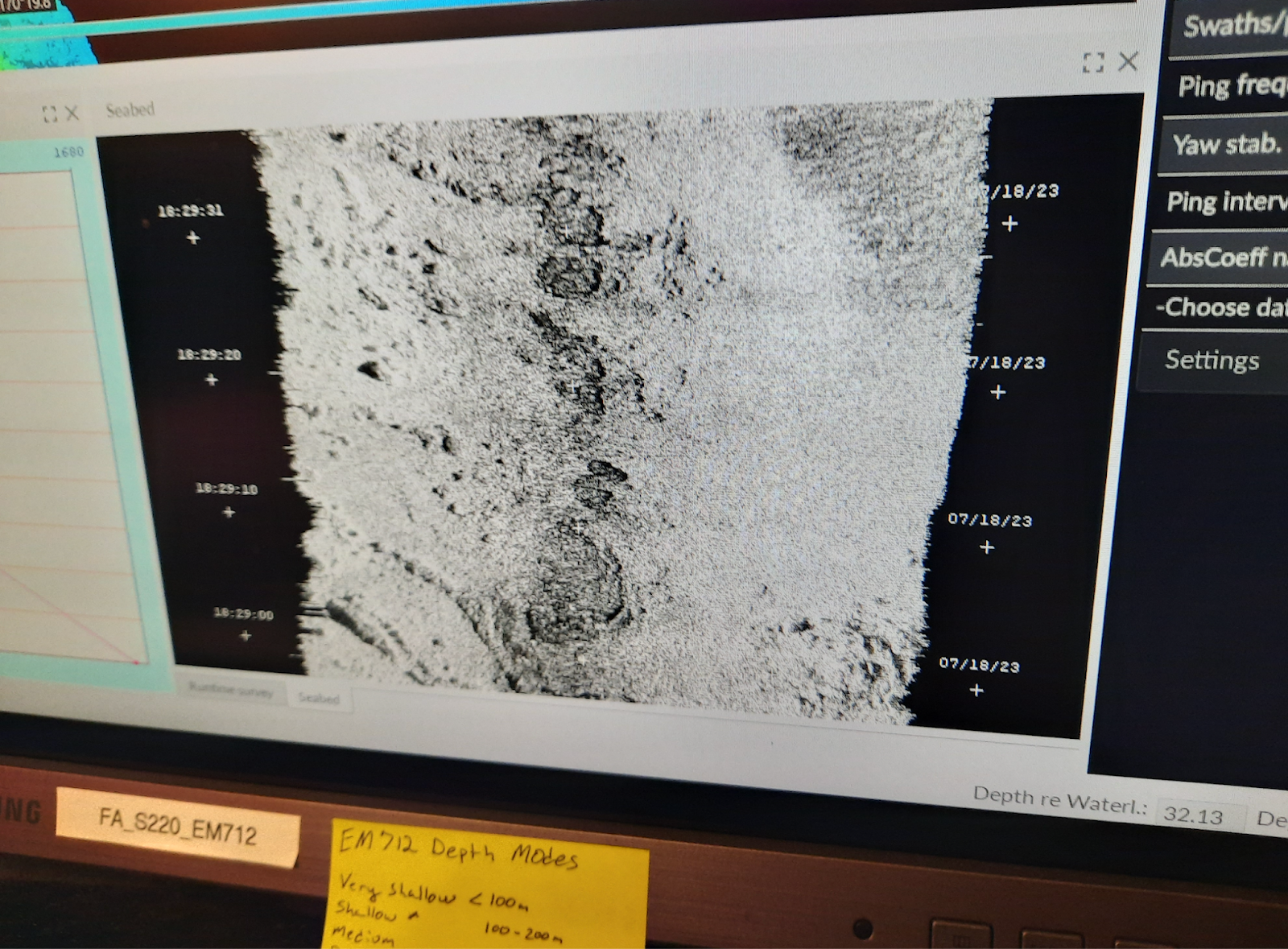 photo of a computer screen displaying seafloor bathymetry (in black and white) from backscatter