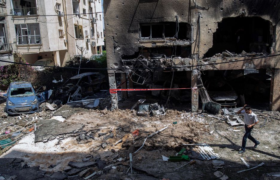 Jovem israelense passa por destroços de foguete lançado de Gaza contra Israel