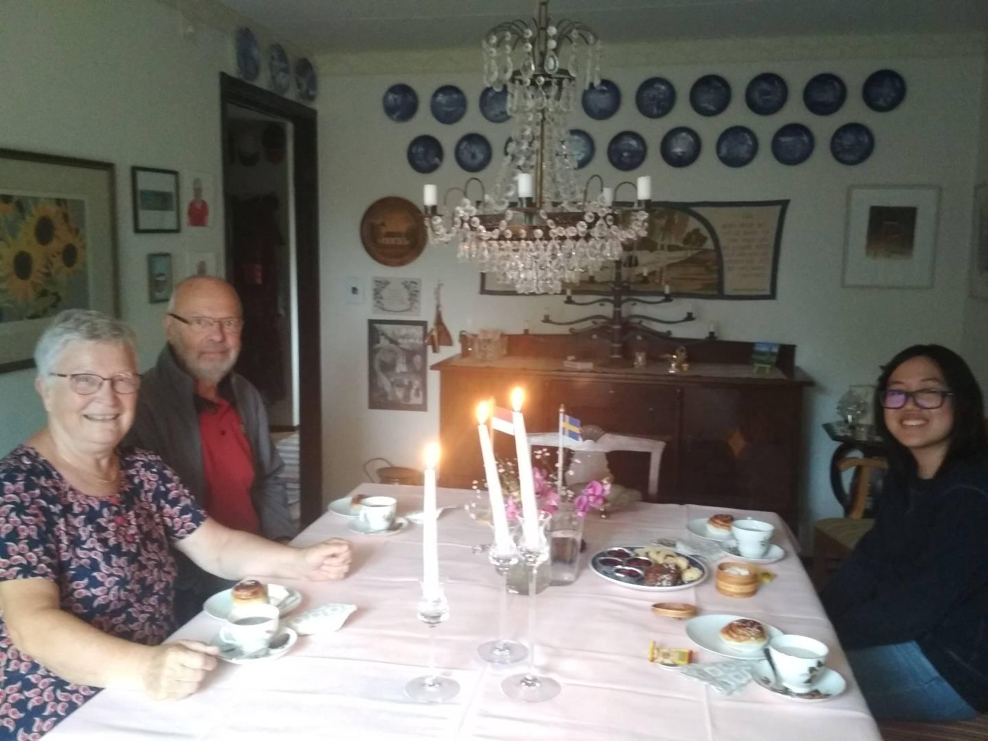 A group of people sitting around a table with food and candles

Description automatically generated with medium confidence