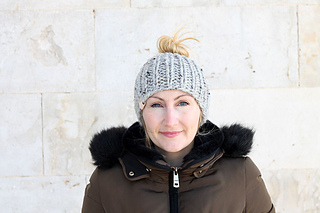 woman wearing bulky knit messy bun beanie outside