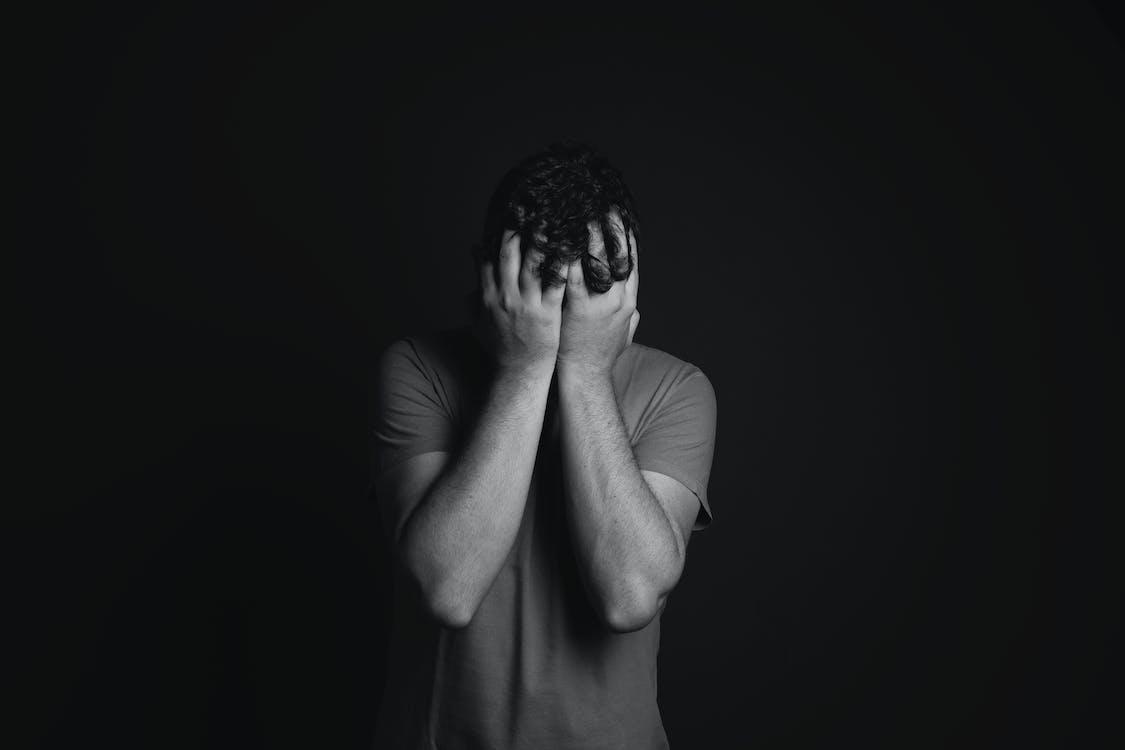 Free Gray scale Photo of Man Covering Face With His Hands Stock Photo