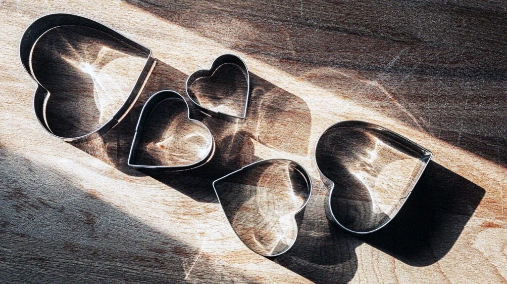 Metal heart shaped baking molds on a table under the sunlight