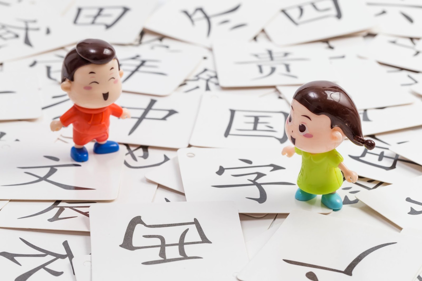 many chinese characters cards with two cartoon dolls.