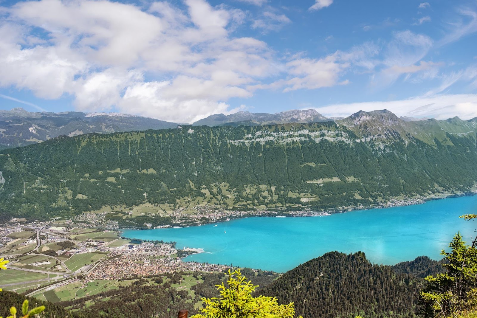 interlaken in the summer seen from above the alps mountains town and blue lake switzerland